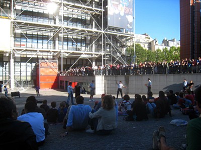 Je patiente en regardant un spectacle comique sur le parvis